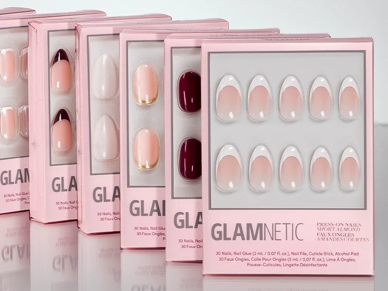 A row of Glamnetic press-on nail boxes in pink packaging, seen at an angle