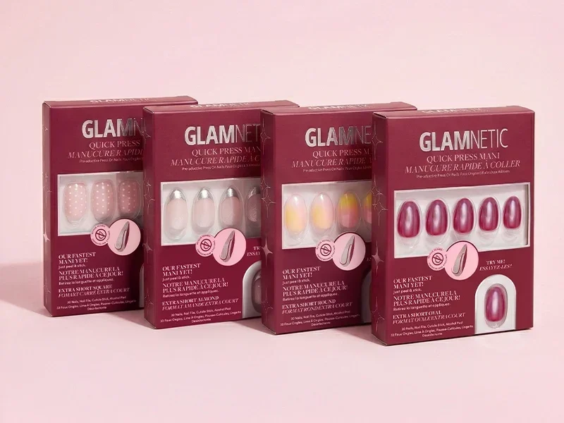 Four Glamnetic Quick Press Mani boxes in burgundy packaging on a pale pink background