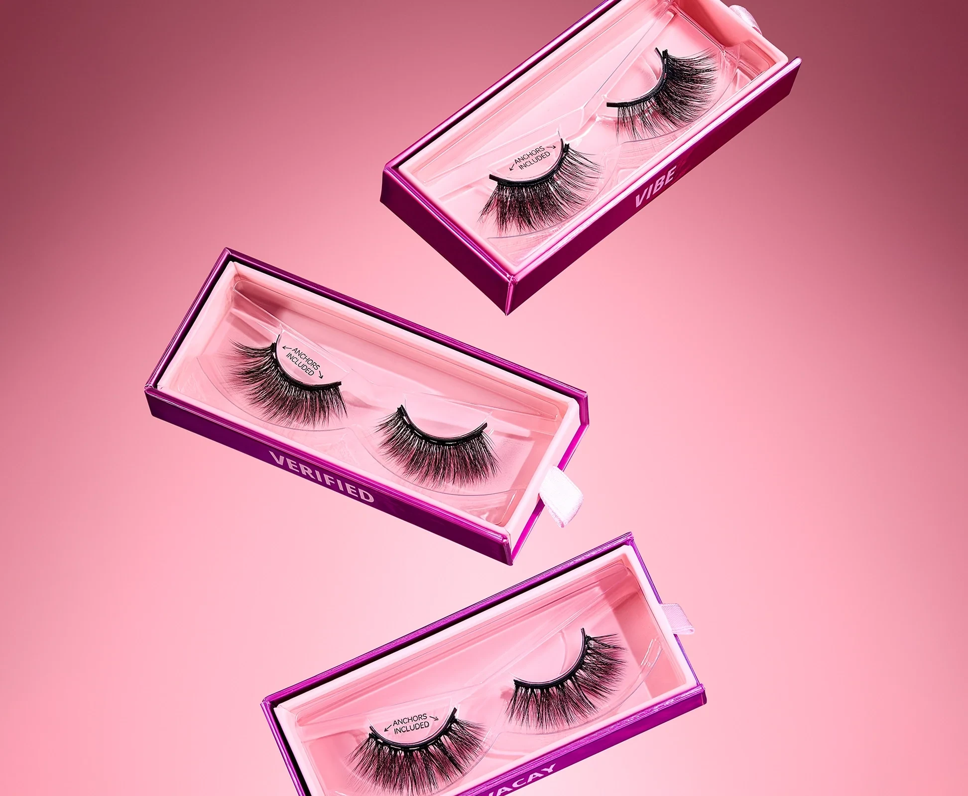 Three Glamnetic magnetic lash sets in pink cases, floating on a pink background