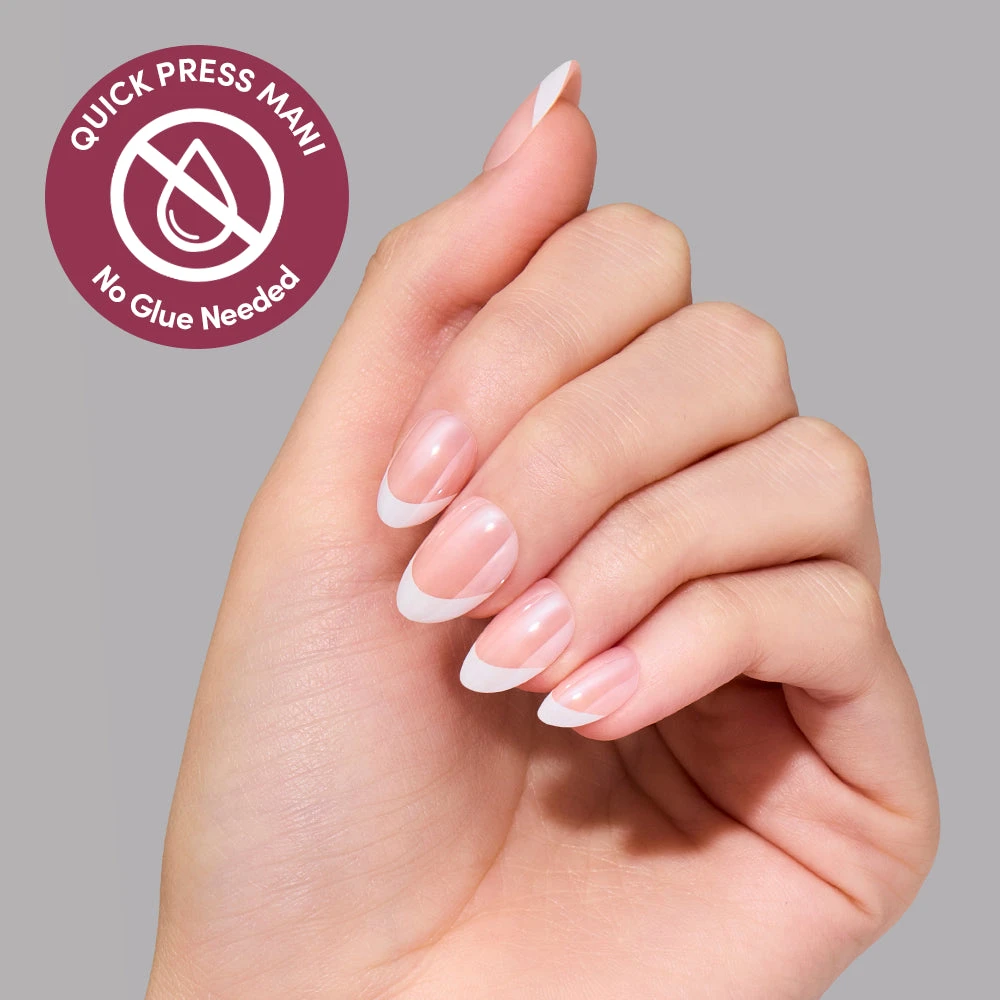Hand wearing Petite Pearls Quick Press Mani, extra short nails with white French tips and a glazed finish